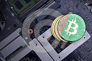 Golden bitcoins with flag of turkmenistan on a computer electronic circuit board. bitcoin mining concept