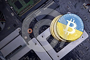 Golden bitcoins with flag of ukraine on a computer electronic circuit board. bitcoin mining concept