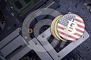 Golden bitcoins with flag of united states of america on a computer electronic circuit board. bitcoin mining concept