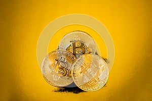 Golden bitcoins on golden background.