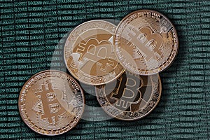 Golden bitcoins on greenish binary code