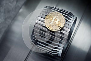 Golden bitcoins lies on the metal gearwheel
