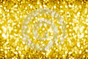 Golden blurred shining bokeh background, defocused yellow sparkles backdrop, gold color round bubbles blur effect, bright lights