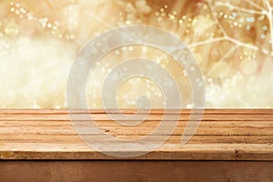 Golden bokeh background with empty wooden table for product montage display