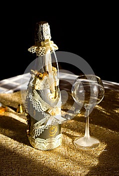 Golden bottle champaign and empty goblet