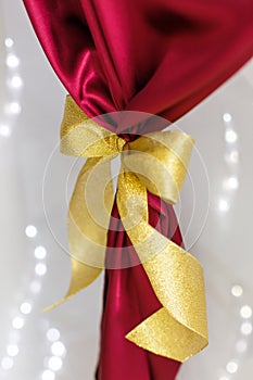 Golden bow on red cloth on a white background