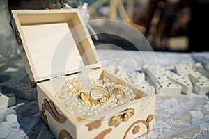 A golden box filled with a pearl necklace is the base for two go