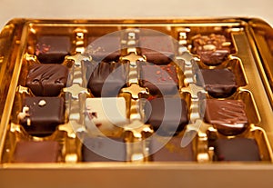 Golden Box of Square Shaped Chocolates in Different Colors and Types