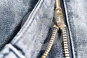 Golden brass zipper on blue jeans. selective focus.
