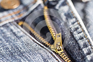 Golden brass zipper on blue jeans. selective focus.