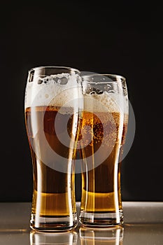 Golden brew with foam, bubbles filling tall glasses.