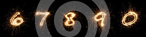 Golden bright sparkler number digits font set collection part 6 to 0 isolated dark black background. silvester new year birthday photo