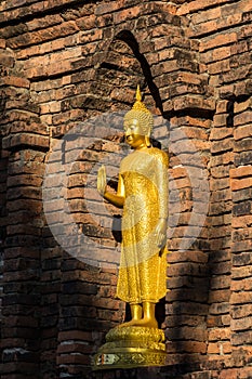 Golden Buddha in front of ancient Maha Chedi in North of Thailand