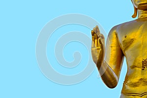 Golden buddha hand on blue sky
