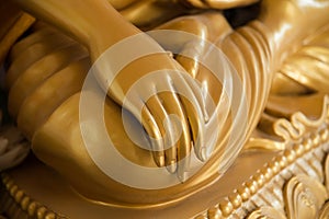 Golden Buddha hand on knee of statue