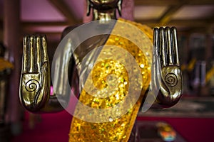 Golden buddha hand with spiral sign with shimmering yellow robe