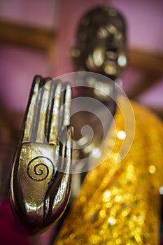 Golden buddha hand with spiral sign with shimmering yellow robe