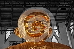 Golden buddha head with modern buildings in background