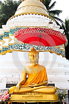 Golden buddha image in front of pagoda at Wat Sri Chum