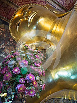 Golden Buddha image head close up with flowers