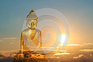 Golden Buddha sculpture and beautfiful sky at sunset on background