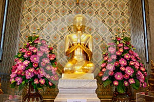 Golden Buddha statue with flowers in Thailand Buddha Temple.