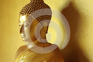 Golden Buddha statue in a golden background