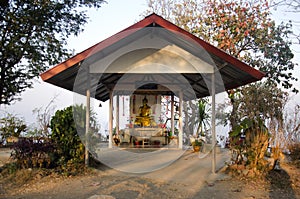 Golden buddha statue in pavilian on top of phu tok mountain