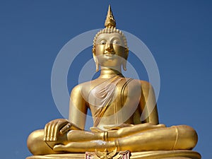 Golden Buddha Statue soars into blue sky