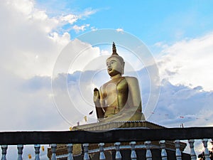 Golden buddha statue with a spectacular of clouds and sky backgr