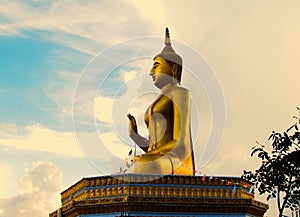 Golden buddha statue with a spectacular of clouds and sky backgr