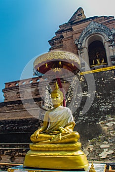 Golden Buddha statue on top of the old pagoda at Wat Chedi Luang temple of the big royal stupa, located in Chiang Mai, Thailand.