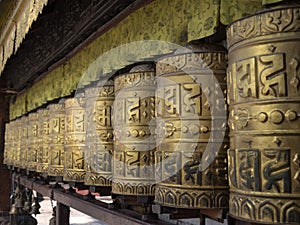 Golden buddhist prayer wheels with the inscription \