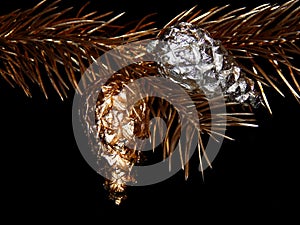 Golden bump on a golden branch of a Christmas tree on a black background