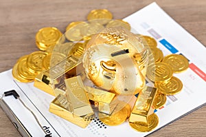 Golden calf piggy bank on gold coins and bars