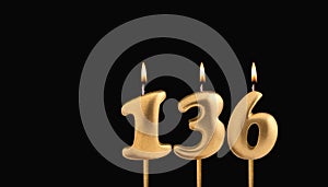 Golden candle 136 with flame - Birthday card on dark luxury background