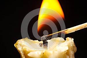 Golden candle burn on black background flame