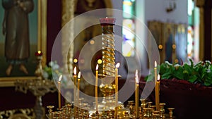 A golden candlestick with burning candles in the church on the altar.
