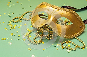 Golden Carnival masks with beads on a green background.