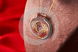 Golden chain with pomegranate shaped pendant, close-up