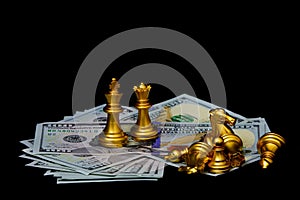 Golden chess pieces on american dollars against dark background