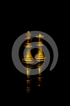 Golden chess pieces king and queen isolated on black background