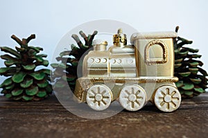 Golden children's toy train. Cones painted with green gouache like small Christmas trees. New Year or Christmas card