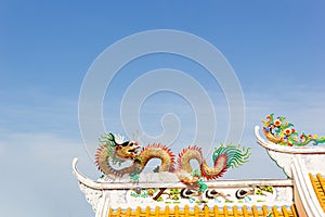 Golden Chinese stucco art on the roof of a Chinese temple on the sky background