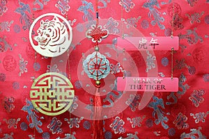 Golden chinese tiger and prosperity symbols and fortune hunger from lucky coins on red fabric with birds and dragons. Chinese New