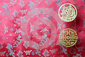 Golden chinese tiger and prosperity symbols on red fabric with chinese ornament birds and dragons. Chinese New Year of the Tiger