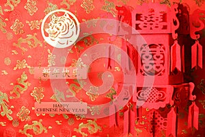 Golden chinese tiger symbol and red chinese lantern on red fabric with traditional chinese ornament of birds and dragons. Chinese