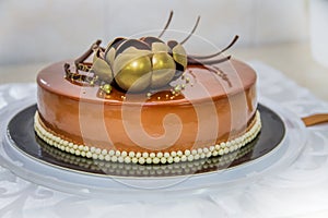 Golden chocolate cake with flower and pearls