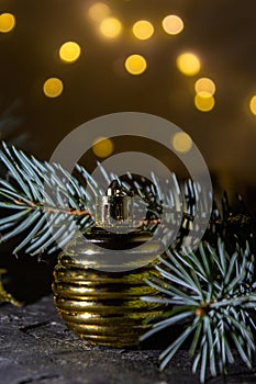 Golden Christmas ball on the Christmas tree. Selective focus. Bokeh background