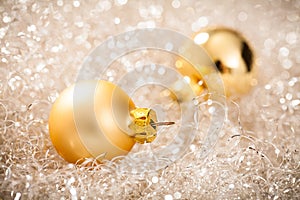 Golden christmas balls lying in silver tinsel